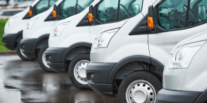 A row of white vans parked together. Commercial auto insurance is critical for businesses that have a fleet of vehicles