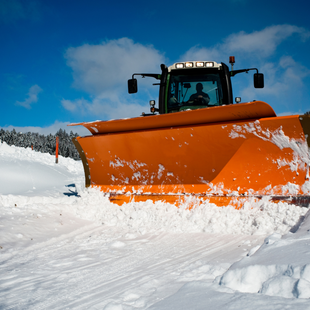 A large snowplow removes snow. reasons why insurance for snow removal contractors is important
